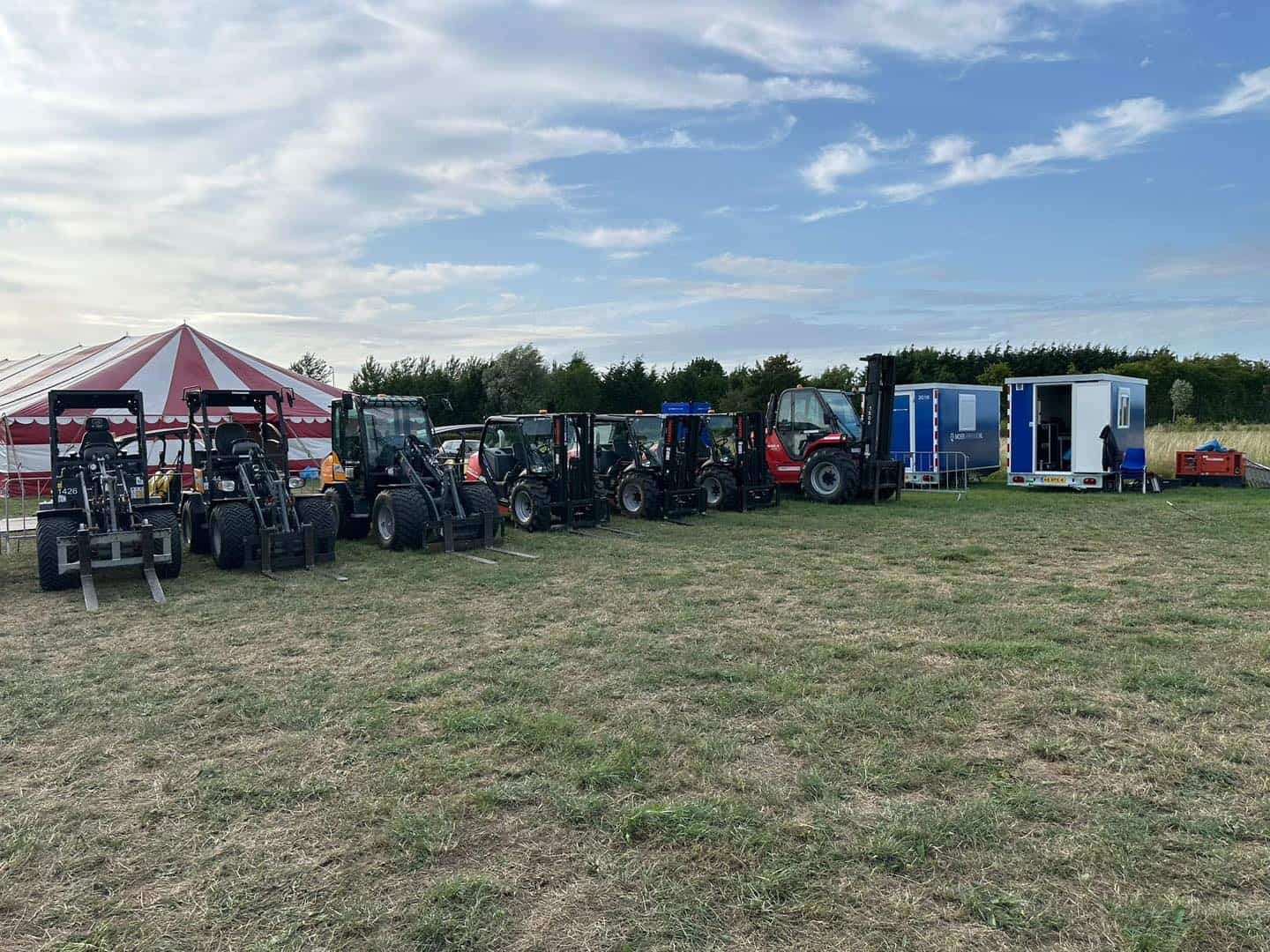 Rij Manitou ruwterreinheftrucks van Moerverhuur op een evenemententerrein, klaar voor inzet